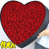 Person holding large black heart shaped box filled with 100 red foam roses