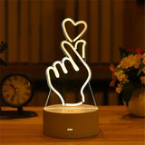 Acrylic LED lamp with etched finger heart gesture design on a wooden base