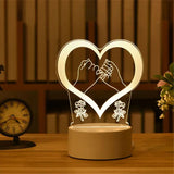Acrylic LED lamp with etched open heart design glowing on a wooden base