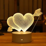 Acrylic LED lamp with etched heart and arrow design glowing on a wooden base
