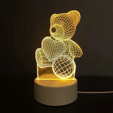 Acrylic night light etched with a teddy bear design on a lit wooden base