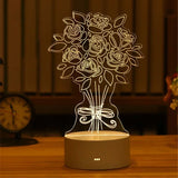 Acrylic night light with etched tree design glowing warm on a wooden base