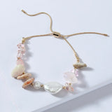 Pale beaded adjustable bracelet with shell and star charms on gold cord