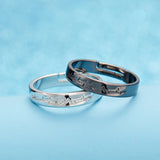 Black and silver couple rings with gemstone accents on light blue background