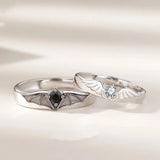 Silver couple rings with angel wing and demon horn design featuring black and clear stones