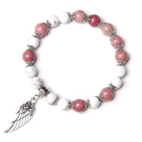 Pink and white natural stone bracelet with silver angel wing charm on white background