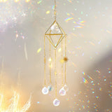 Backlit gold geometric suncatcher with crystal beads glowing in direct sunlight
