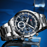 Blue chronograph dial with silver hands and steel bracelet on a blue backdrop