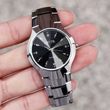 Silver steel couple watches with black dial held together close up in hand