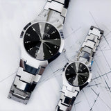 Silver steel couple watches with black dial displayed together on a marble surface