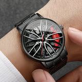 Black car wheel style watch with red caliper accent worn on wrist with white sleeve