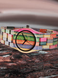 Colorful bamboo wood watch shown close up on a textured rock surface