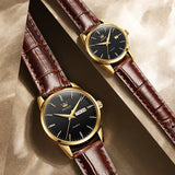 Gold blue dial couple watches with brown leather straps resting on wooden surface