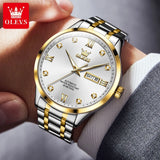 Two-tone silver and gold watch with white dial worn on wrist with a suit sleeve