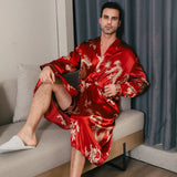 Man wearing a red silk robe with gold dragon embroidery seated on a sofa
