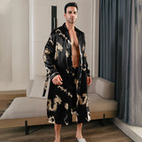 Man wearing a black silk robe with gold dragon embroidery seated with open front