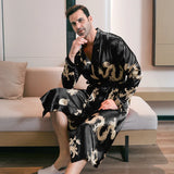 Man wearing a black silk robe with gold dragon embroidery seated on a wooden bench