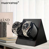 Black carbon fibre pattern dual watch winder holding two automatic watches on a desk