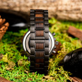 Side view of ebony wood and steel link bracelet on moss and greenery