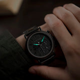 Wrist wearing dark ebony wood chronograph watch with grey dial