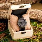 Wooden chronograph watch presented in an engraved wood gift box on moss