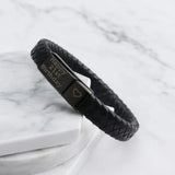 Close-up of the black braided leather bracelet clasp on marble background