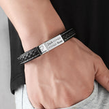 Black braided leather bracelet with engraved silver plate worn on wrist