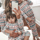 Adult holding a toddler, both in matching Fair Isle Christmas pyjamas