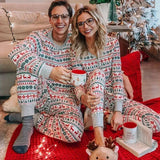 Two adults and a child wearing matching grey Fair Isle Christmas pyjama sets