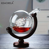 KEMORELA etched glass globe decanter with stopper on dark wood stand on a desk