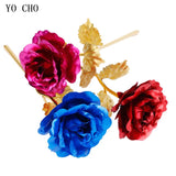 Red and blue gold plated roses with gold stems and leaves side by side