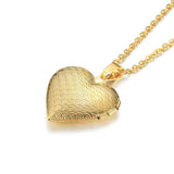 Close-up of gold heart photo locket with fine textured pattern on a chain