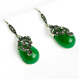 Silver drop earrings with green teardrop stones and crystal accented scrollwork