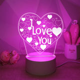 Heart LED night light glowing pink beside small decorative hearts on a shelf