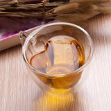 Empty heart shaped double wall glass cup shown from a side angle