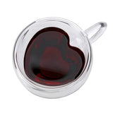 Heart shaped double wall glass cup filled with dark red liquid on white background