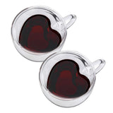Two heart shaped double wall glass cups filled with dark red liquid side by side