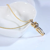 Silver and gold hugging couple pendant necklaces draped over a white vase