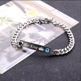 Stainless steel curb chain bracelet with rose gold ID bar laid out on white
