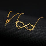 Close-up of gold infinity pendant necklace with custom names and heart accent