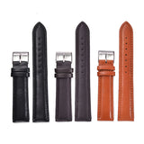 Four leather watch straps in black, dark brown and tan laid side by side with buckles