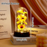 Gold foil rose in a lit glass dome on a dark base with warm fairy lights