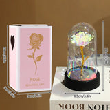 Gold foil rose glowing under a glass dome with warm LED lights and pink petals