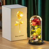 Gold foil rose in a lit glass dome shown beside its white printed gift box