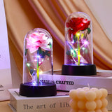 Purple and pink galaxy rose in a lit glass dome on a wooden base with curtains behind