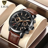 Black dial chronograph watch with gold hands and brown leather strap in presentation box