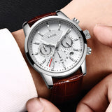 Hand holding white dial chronograph watch showing case size against the fingers