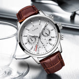 White dial chronograph watch with brown strap photographed beside clear glassware