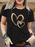 Close-up of black t-shirt with gold heart outline graphic worn on torso