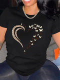 Close-up of black t-shirt with gold swirl heart graphic worn on torso